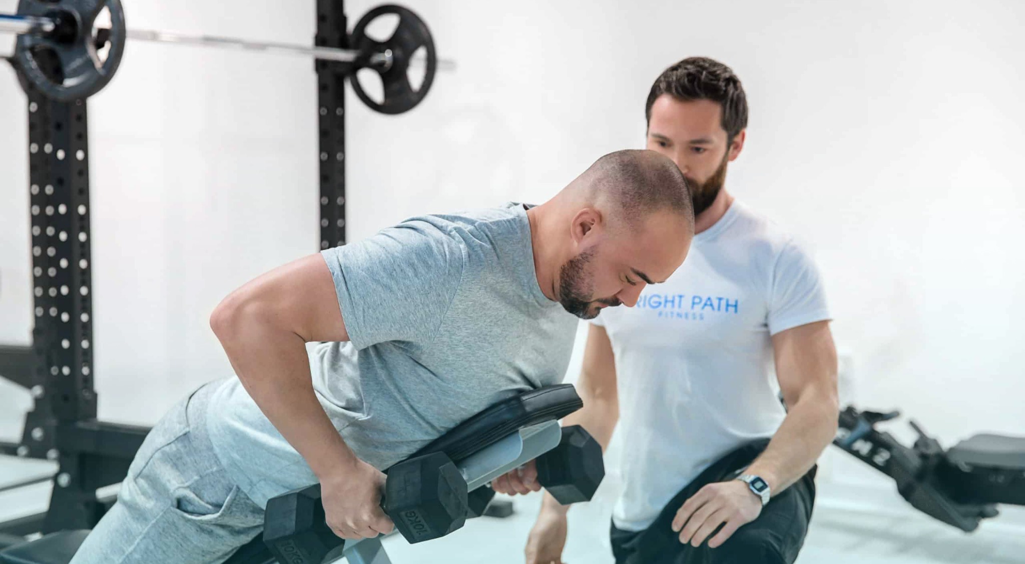 Keith McNiven coaching a client with dumbbells