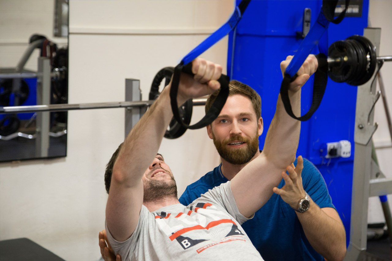 Personal trainer coaching a client during a body transformation session